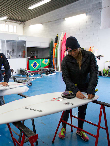 Carlos Burle and Maya Gabeira prepare surfboards in Nazare, Portugal