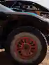Carlos Sainz and Lucas Cruz's Raptor T1+ rally car at Rally Du Maroc 2024 in Morocco, featuring prominent Red Bull branding and large off-road tyres