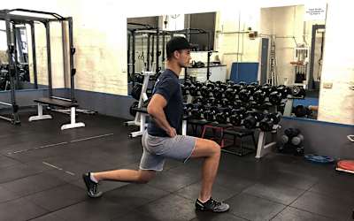 Un atleta realiza lunges en un gimnasio.
