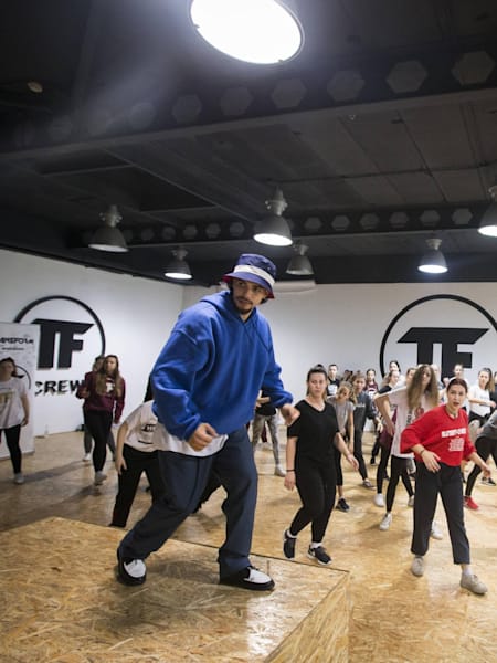 Greeteck dancing on a pedestal in front of his students.
