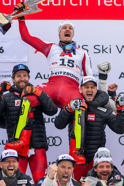 Manuel Feller lifts his trophy at Kitzbühel, Austria, as he is lifted by his teammates in an emotional ski victory moment in January 2026.