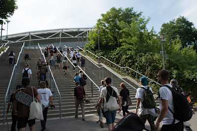 Die Fans gehen die Treppen zum Stadionvorplatz an der Red Bull Arena rauf.