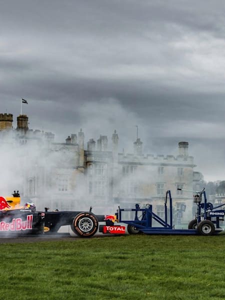 Daniel Ricciardo bringt seinen Red Bull Racing RB8 gegen die Bath Rugby Manschaft in Stellung und schiebt los.