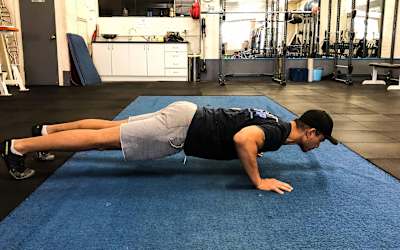 Un atleta realiza flexiones en el gimnasio.