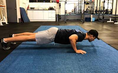 Un atleta realiza flexiones en el gimnasio.