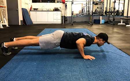 Un atleta realiza flexiones en el gimnasio.
