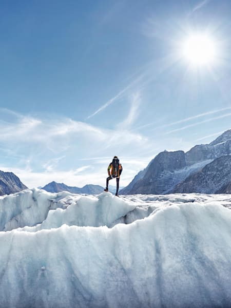 Hiker seen standing on glacier surrounded by Aletsch Glacier, Switzerland.