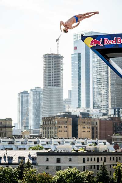 En 2024, Gary Hunt se zambulle acrobáticamente en el evento Red Bull Cliff Diving de Montreal.