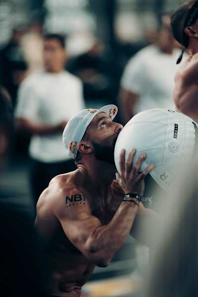 Alexander Rončević is captured mid-action at HYROX Phoenix 2026 in Arizona, USA, wearing a Red Bull hat and preparing to throw a wall ball.