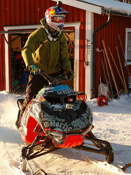Daniel Bodin poses on his snowmobile outside his garage in Sweden