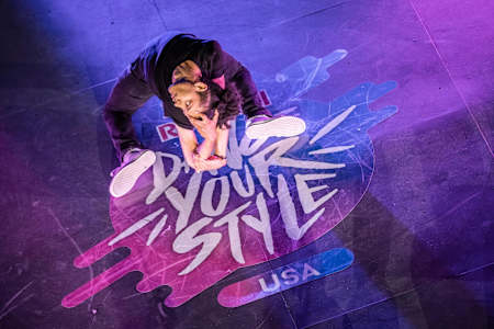 Skitzo posa de rodillas con una mano en la cabeza.