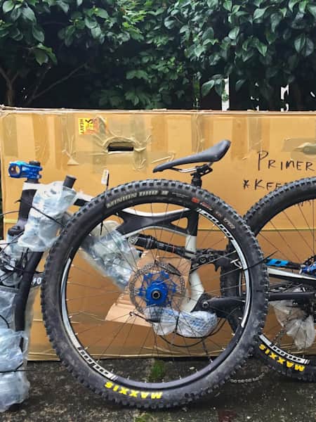 A mountain bike ready to load into a cardboard bike box for transportation.