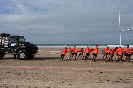 England players pull a truck across the beach in Jersey for Red Bull Stress Test