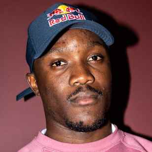 Botswanan sprinter Letsile Tebogo poses in a Red Bull cap and pink Nike Sweatshirt.