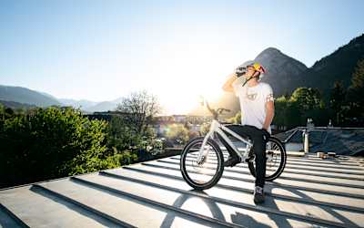 MTB rider Fabio Wibmer drinks a Red Bull as the sun goes down on top of his roof in Austria.