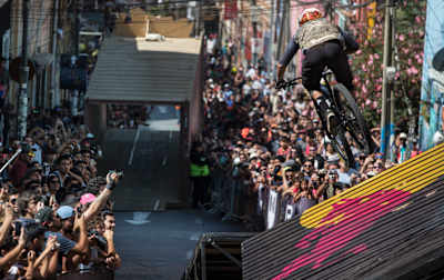 Un participant de la compétition de VTT DH urbain Red Bull Valparaiso Cerro Abajo descend la piste devant la foule dans la ville de Valparaiso au Chili.