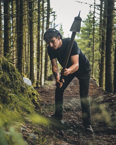 A dig crew worker works on the Red Bull Hardline course in 2022.