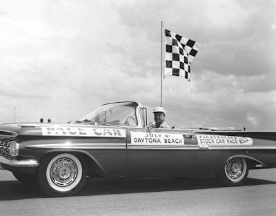 A photo of Walter Cronkite at the wheel of the pace car for the 1959 Firecracker 250 at Daytona.