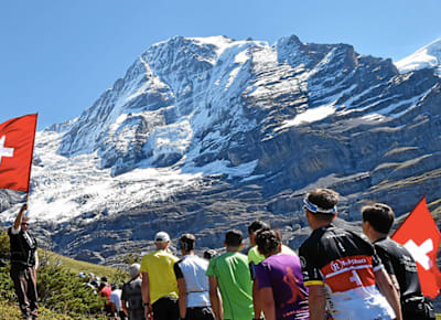 Eine Reihe an Teilnehmern des Jungfrau-Marathon schlängelt sich durch die Schweizer Berglandschaft.