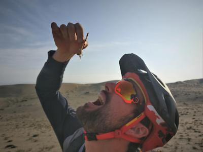 Le rider de VTT Kilian Bron mange un scorpion séché sur le Cerro Blanco au Pérou dans "MISSION".