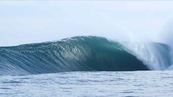 An empty wave barrels over a reef in Indonesia.