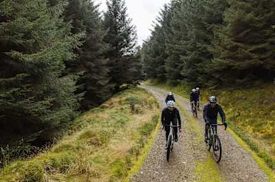 A group of gravel riders amidst the trees.