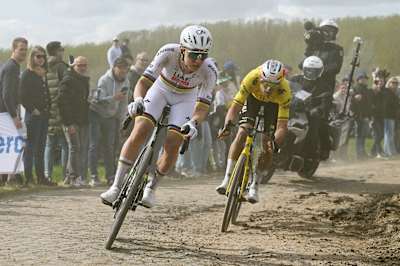 Tadej Pogacar and Wout van Aert compete in the breakaway while fans cheer during the 123rd Paris-Roubaix Hauts-de-France 2026 on April 12, 2026 in Roubaix, France.