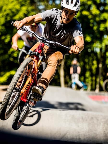 Gaetan Vige rides a pump track with a fellow MTB rider.