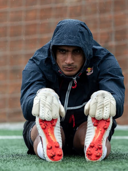 Gurpreet Singh Sandhu stretches on a football pitch.