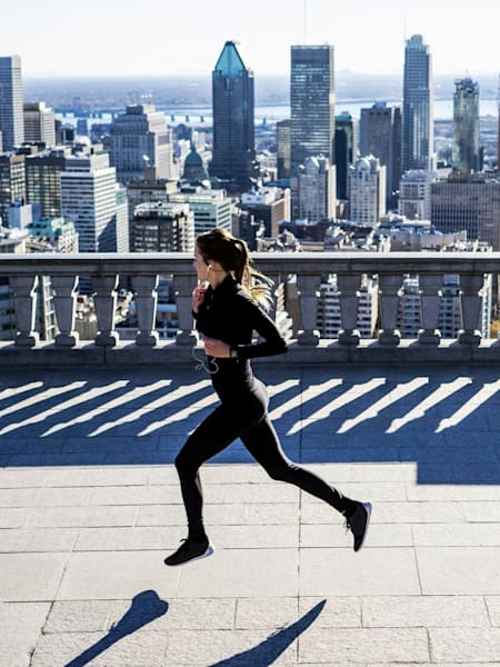 A runner passes a cityscape view high above a city.