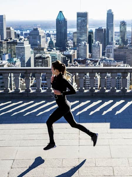 Una runner si allena davanti allo skyline di una metropoli.