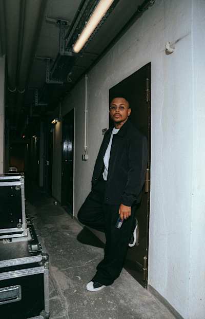 Luciano bei einem Fotoshooting in einem dunklen Flur.