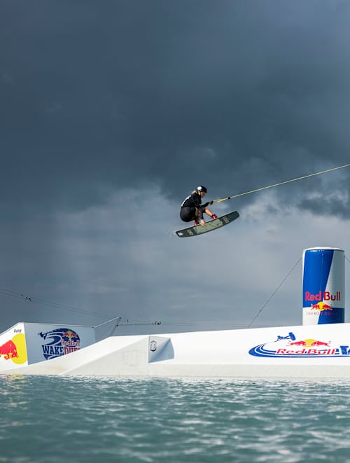 Athlete Rivers Hedrick performing trick on obstacle on obstacle in front of a crowd seen at Red Bull WakeDuel in Palanga, Lithuania on the 8th of June 2024.