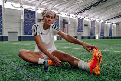 La joueuse de football américaine Trinity Rodman s'étire les ischio-jambiers lors d'une séance de stretching.