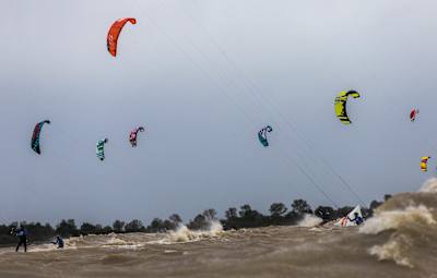 Des riders affrontent les vagues lors d’une session de kitesurf.
