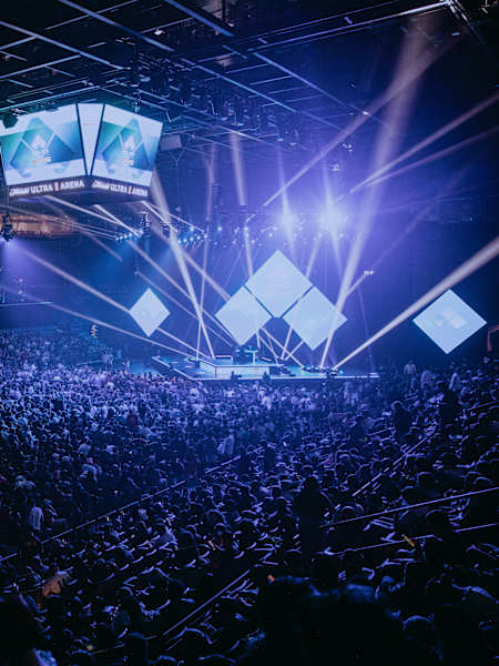 A huge crowd watches a spectacular light show at the Michelob Ultra Arena during the EVO Championship Series 2023 in Las Vegas.