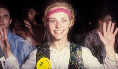 A smiling raver, with her hands in the air, Shoom, London, UK 1988