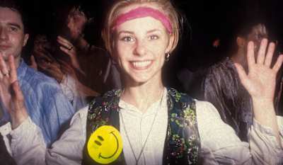 A smiling raver, with her hands in the air, Shoom, London, UK 1988