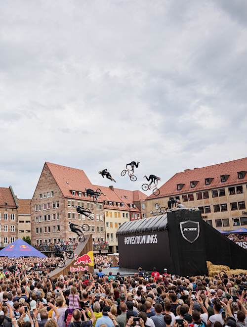 An MTB rider performs in front of spectators at Red Bull District Ride 2022 in Nuremberg, Germany