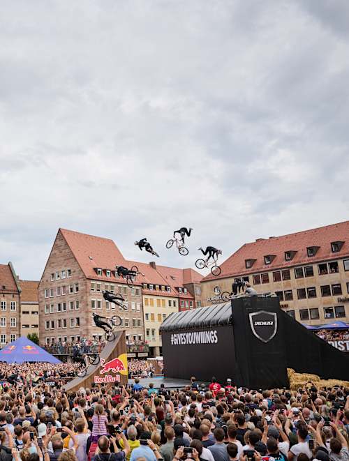 Un rider VTT réalise une figure devant les spectateurs lors du Red Bull District Ride 2022 à Nuremberg, en Allemagne.