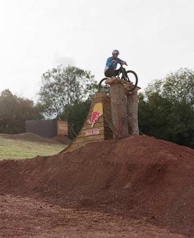 Le rider britannique Matt Jones franchit un obstacle en VTT slopestyle pendant le tournage de la série "Design and Conquer".
