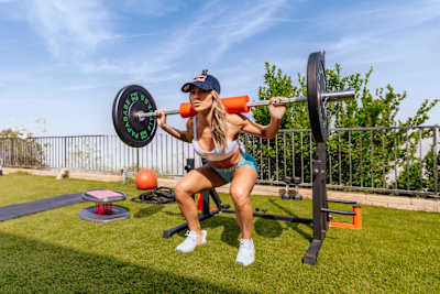 La skateuse pro Leticia Bufoni réalise un squat avec des haltères lors d'un entrainement.