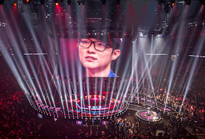 Young Faker : le GOAT au centre, en 2015 lors de la finale des Worlds. Son visage dans la Mercedes-Benz Arena accueillant l’event. Ce kid devint une icône mondiale.