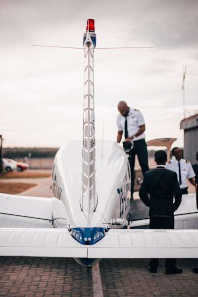 An instructor from the iFly Academy, South Africa's first black-owned aviation school, shows school students around a small plane.