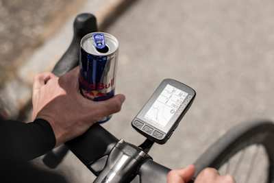 Ein Rennradfahrer fährt mit beiden Händen oberhalb des Lenkers.