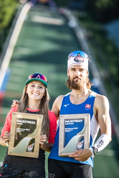 Magdalena Kozielska of Poland and Tomas Celko of Slovakia celebrate with their winners trophies at the Wielka Krokiew ski-jump.