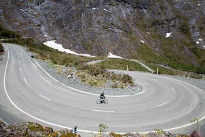 A female cyclist rides her bike down a mountain road in Fiordland, New Zealand, on November 19th, 2011.