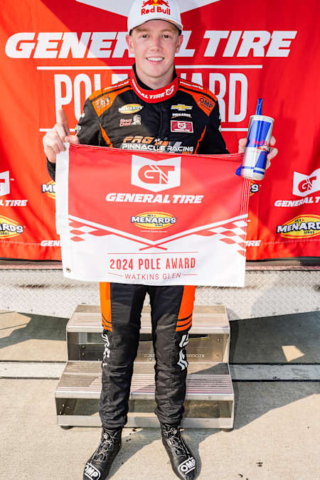 Connor Zilisch celebrates with the pole award flag at Watkins Glen International 2024 in Watkins Glen, New York.
