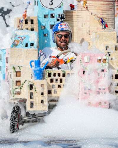 A custom built Red Bull Soapbox Race car speeds through mountains of bubbles