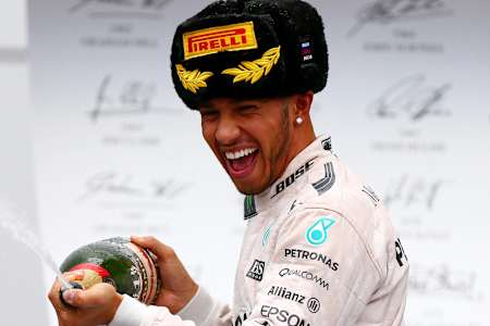 Lewis Hamilton feiert mit Champagner und traditioneller Pirelli-Pelzmütze nach seinem Sieg beim Grand Prix von Russland in Sotschi.